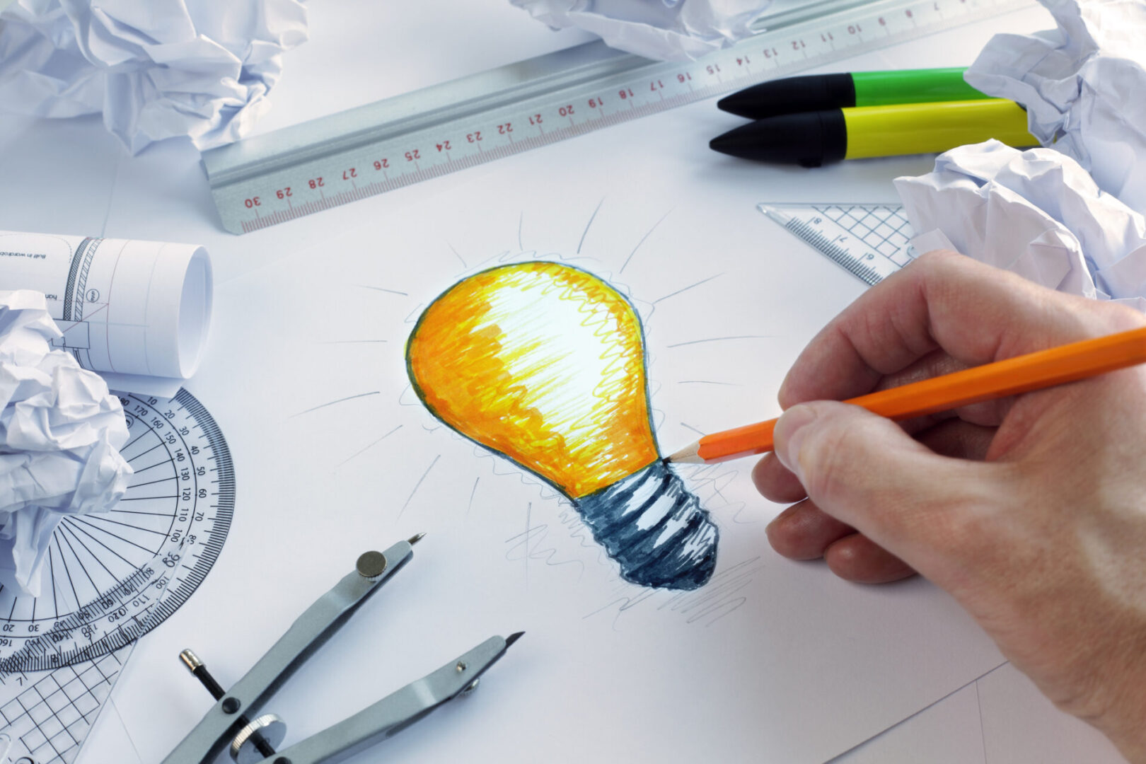 A person drawing an image of a light bulb.