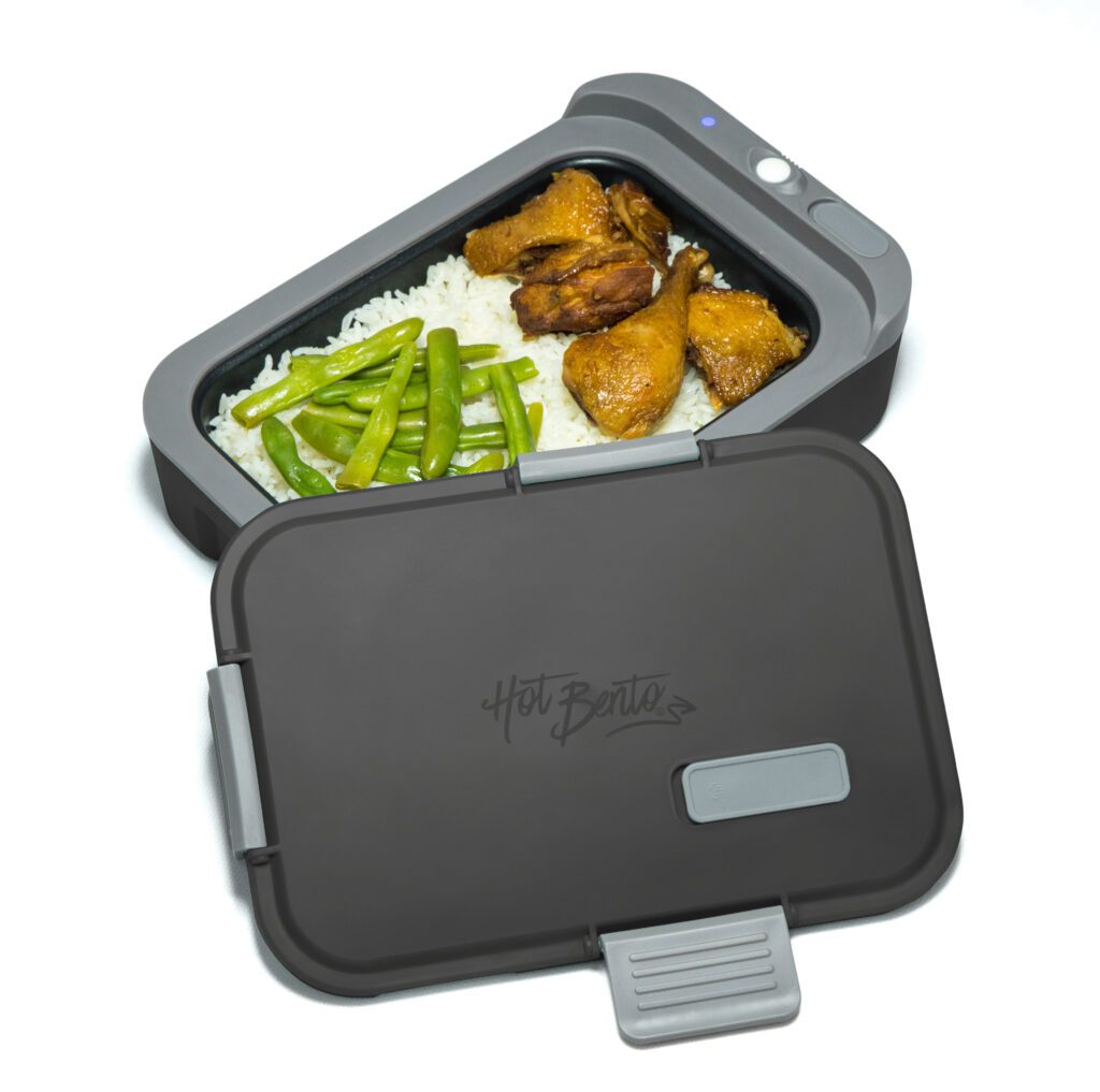 A lunch box with food inside of it with white background
